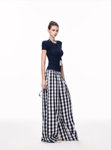 Detail of slim fit navy blue short sleeve t-shirt and high waist black plaid wide leg pants