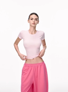 Close-up of pink slim-fit t-shirt in ribbed fabric paired with rose red sweatpants
