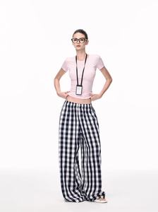 Detail of pink slim-fit t-shirt paired with black and white checkered wide-leg pants