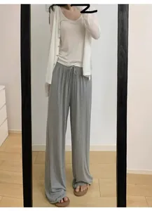 Détail du pantalon large gris avec taille élastique à cordon et tissu drapé fluide