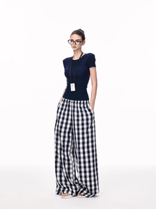 Close-up of slim-fit navy t-shirt paired with high-waisted black and white checkered pants