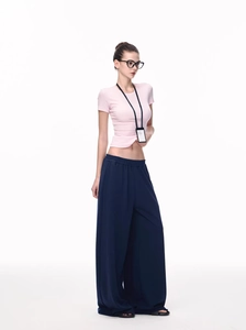 Detail of pink slim-fit crop t-shirt paired with navy high-waisted wide-leg trousers