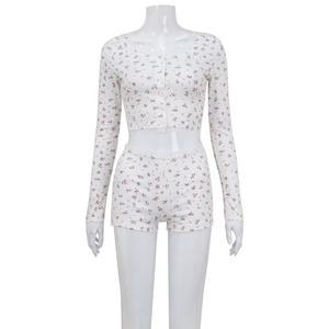 Detail of floral two-piece loungewear with lace trim and ribbed texture on white fabric