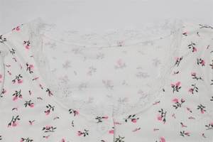 Close-up of ribbed floral fabric with lace V-neckline and a single white button detail