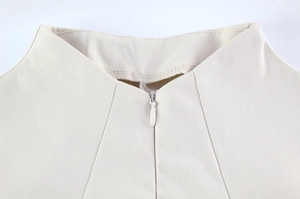 Detail of the high-quality invisible zipper on the neckline of a beige slim-fit dress