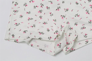 Close-up of ribbed fabric texture with floral print and neat twin-needle stitching