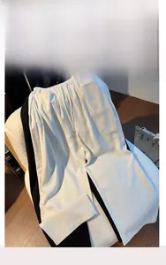 Detail of elastic waist and vertical seam on wide-leg trousers in black and white