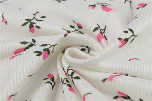 Macro shot of ribbed texture fabric with delicate pink and green floral print on white