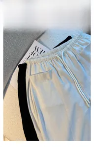 Detail view of high waist elastic waistband with drawstring and cargo pockets on trousers