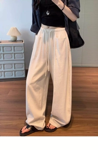 Detail of high waisted casual trousers showing elastic drawstring waist and side pockets