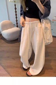Detail view of elastic drawstring waist and pocket on women's off-white wide leg pants