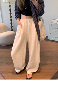 Detail of off-white wide-leg casual pants with elastic drawstring waist and textured fabric