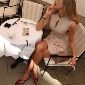 Sleeveless slim fit beige dress with zipper front detail styled with red shoes