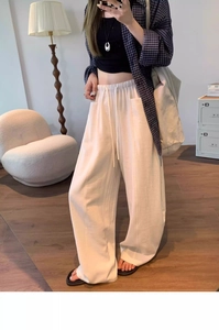 Detail of white elastic waist trousers with drawstring and functional side pockets