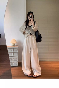 Detail view of high-waisted wide-leg trousers with drawstring elastic waist and side pockets