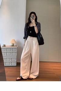 Close-up of elastic drawstring waistband on flowy cream wide-leg lounge pants