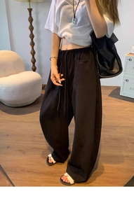 Detail of black wide-leg trousers with elastic drawstring waist and side pockets