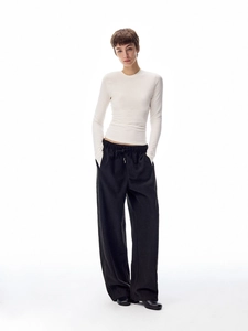 Detail of white long sleeve slim crewneck top and black wide leg drawstring pants