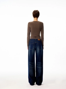 Rear view of a slim brown long sleeve t-shirt and wide-leg denim jeans on a model