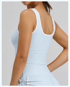 Detalle de camiseta de yoga azul claro con espalda en U y bordes blancos en contraste
