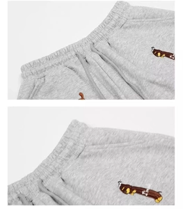 Detail view of grey sweatpants featuring a cute dachshund embroidery and drawstring waist