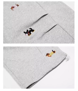 Detail of embroidered dachshund motifs on grey cotton sweatpants with white drawstring
