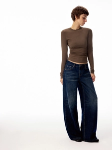 Detail view of slim fit long sleeve crew neck top paired with wide leg jeans