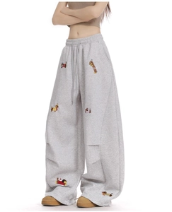 Detail of embroidered dachshund motifs on gray wide-leg drawstring sweatpants