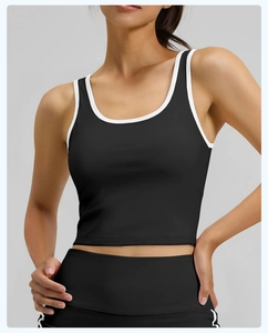 Detalle de top deportivo negro con ribete blanco en contraste y tejido elástico mate