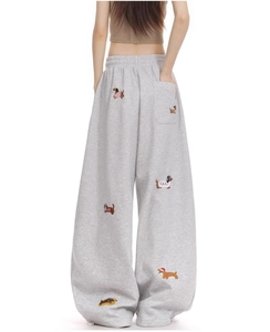 Detail of grey wide-leg joggers featuring colorful cartoon sausage dog embroidery