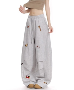 Detail of grey wide-leg sweatpants featuring cute cartoon dachshund embroidery and drawstring