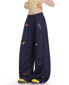Detail of colorful dachshund embroidery and drawstring waist on navy wide-leg sweatpants