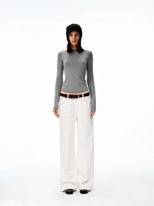 Close-up of a slim fit grey long sleeve T-shirt styled with white high waist wide leg trousers
