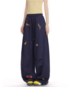 Detail of dachshund embroidery and colorful patches on navy blue wide-leg sweatpants