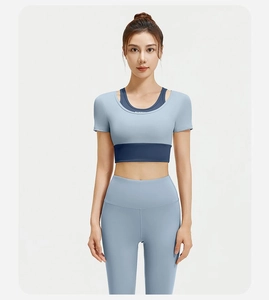 Detail van tweekleurige blauwe yogatop met RUNNING-print en sportleggings met hoge taille