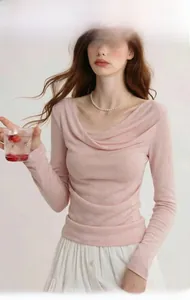 Detail of pink long-sleeve knit top featuring a draped cowl neckline and slim fit design