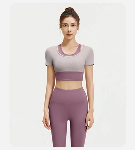 Detail van paarse yoga legging en grijze hardloop top set gedragen door model
