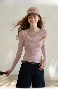Detail of elegant pink long sleeve knit top with stylish draped pleated neckline design