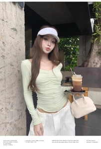 Detail of light green V-neck long sleeve top with ruched gathering texture and slim fit