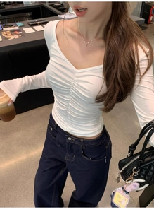 Close-up of white V-neck long sleeve top with front ruched detail and slim fit design