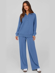 Detailed view of women's blue two-piece tracksuit with long sleeve polo and wide leg pants