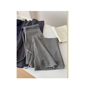 Dettaglio di pantaloni sportivi grigi e blu con coulisse su una scrivania bianca