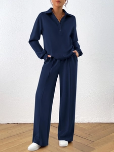 Close-up of navy blue long sleeve polo top and wide-leg trousers with front seam details