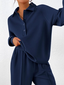 Detail of dark blue two-piece sportswear set featuring polo collar sweatshirt and joggers