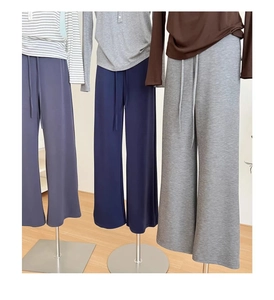 Dettaglio dei pantaloni larghi a vita alta con coulisse nei colori viola, navy e grigio