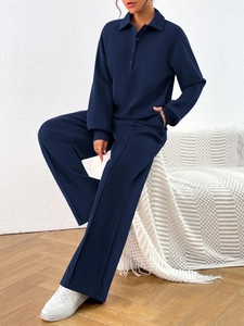 Detail of dark blue long-sleeve polo top and wide-leg trousers with vertical seams