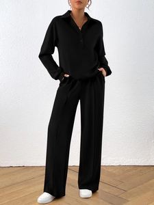 Detail view of black long sleeve polo top and wide-leg trousers with center seam