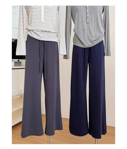 Dettaglio dei pantaloni sportivi a vita alta con coulisse in grigio e blu scuro