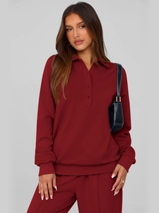 Detail of dark red long-sleeved polo sweatshirt with three buttons and ribbed cuffs