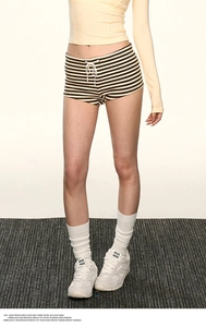 Dettaglio macro degli hot pants in maglia a righe con coulisse a fiocco bianco davanti